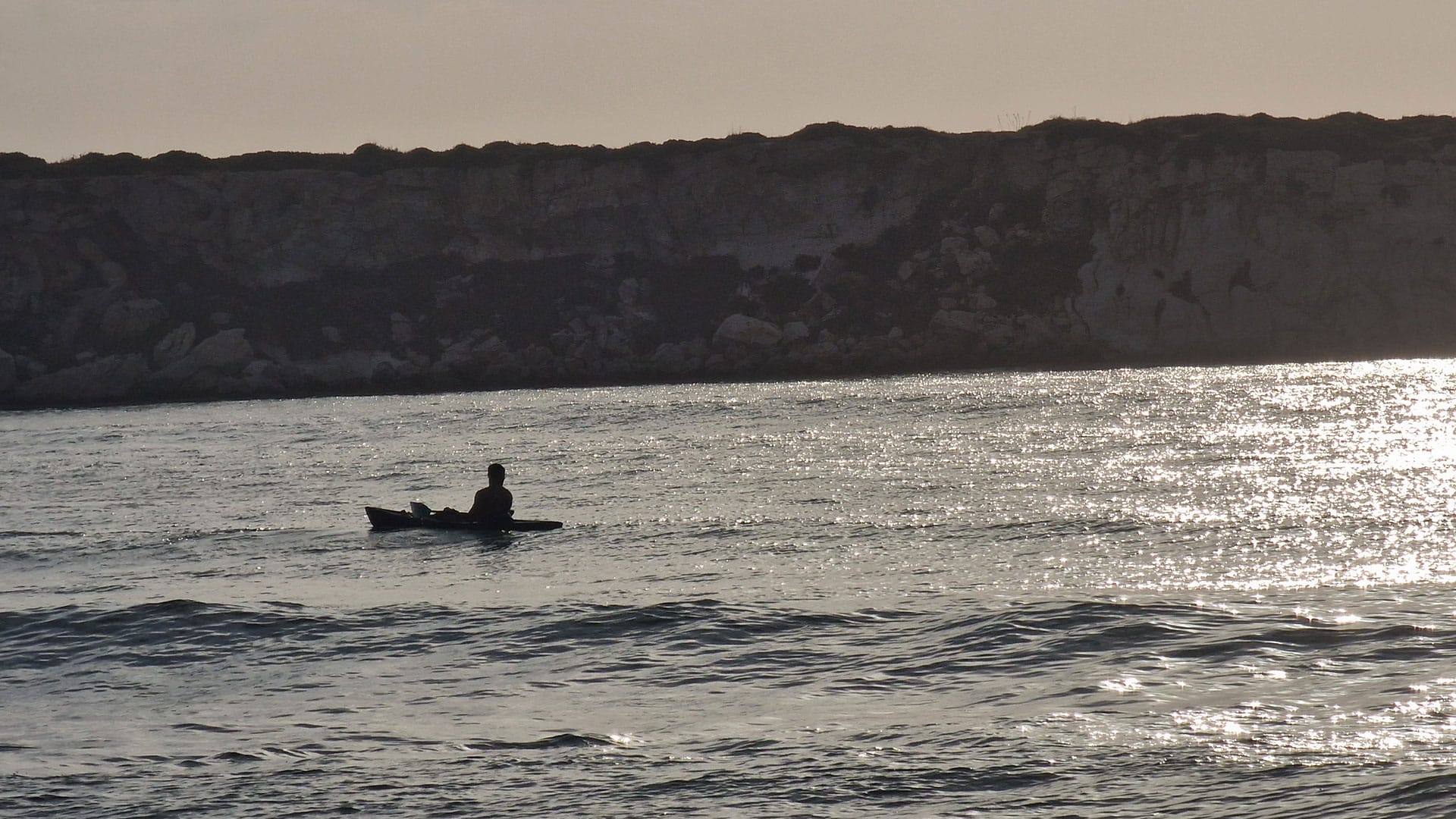 a man kayaking in the sunset